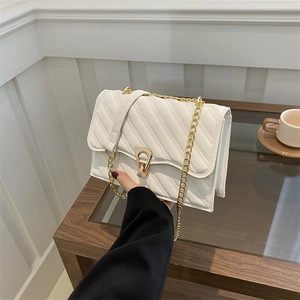 Elegant white quilted crossbody bag with gold chain strap and metal lock closure
