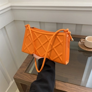 Bright orange quilted shoulder bag with fine stitching and golden metal hardware
