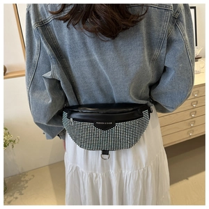 Detail of crossbody chest bag featuring sparkling silver rhinestones on black leather