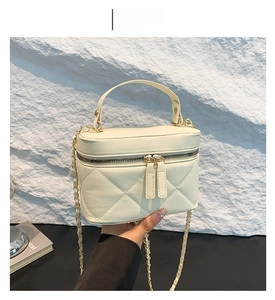 Detail of off-white quilted crossbody bag featuring chain strap and textured leather finish