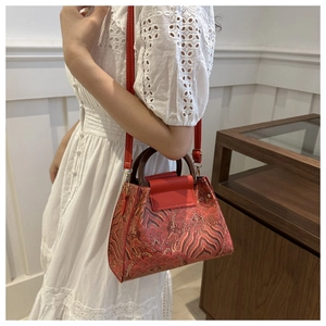 Detail of vintage red bucket bag with floral embroidery and round wooden handles
