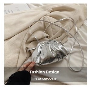Macro view showing the silver metallic cloud bag texture and ruched leather details