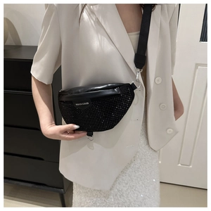 Detail of black rhinestone chest bag with nylon strap on a model wearing a white suit