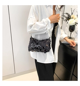 Close-up of black sequin shoulder bag with shiny reflective texture and silver chain strap