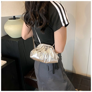 Detail of silver metallic dumpling bag with pleated texture and fine chain strap