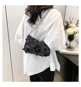 Detail of black sequin shoulder bag with silver chain strap and shimmering texture