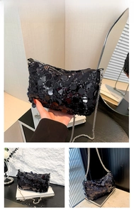 Detail of a black sequin crossbody bag with a slim silver chain strap and shiny finish