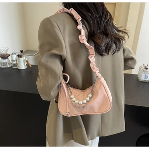 Vue détaillée du sac sous l'aisselle rose froncé avec perles décoratives et chaînette