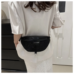 Detail of a black crossbody bag with shimmering rhinestones and FASHION & BAGS tag
