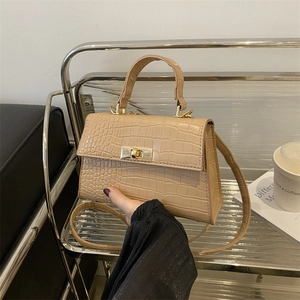 Beige crocodile pattern crossbody bag with golden metal rotary lock and top handle