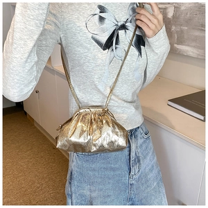 Sac bandoulière doré à cordon avec texture plissée métallique porté par mannequin