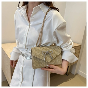 Sac bandoulière en paille avec nœud papillon en strass argentés et chaîne dorée