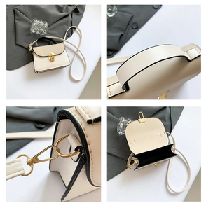 Detail view of mini cream shoulder bag with black contrast trim and gold metal clasp