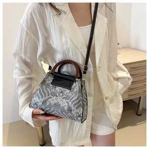 Close-up of retro bucket bag featuring Great Wave embroidery and round wooden handles