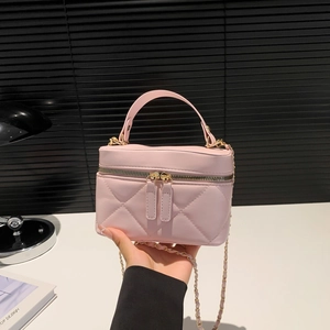 Pink quilted leather box bag with chain strap and dual zippers in hand for women