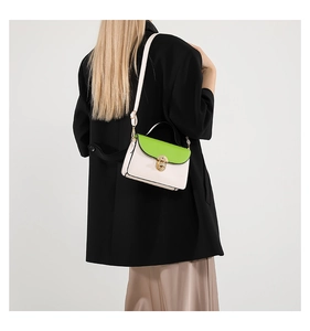 Model showing contrast color small square bag with golden lock and adjustable strap