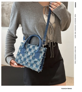 Model mit einer blau karierten Denim-Umhängetasche mit Fransen und Ledergriffen