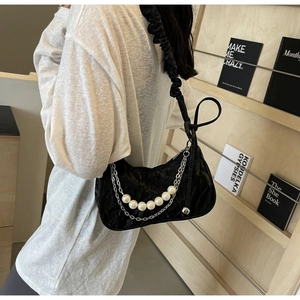 Détail du sac à bandoulière plissé noir avec chaîne argentée et perles blanches