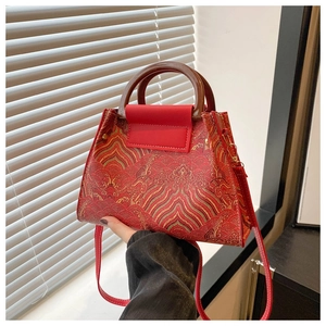Detail of red brocade bucket bag with gold cloud embroidery and wooden handle