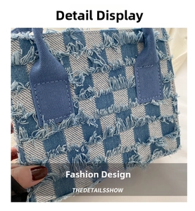 Detail der blau-weiß karierten Jeanshandtasche mit Fransen und Distressed-Struktur