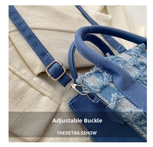 Detail der blauen Denim-Umhängetasche mit verstellbarer Metallschnalle und Fransenkante