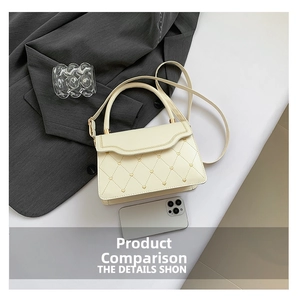 Detail of cream-white quilted handbag with golden heart studs and woven border trim