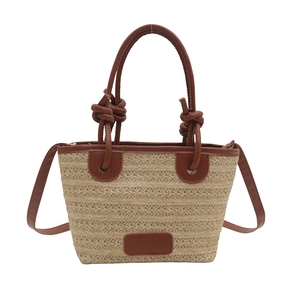 Handwoven straw tote bag with brown leather handles and a long shoulder strap for women