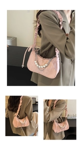 Détail du sac sous l'aisselle rose plissé avec chaîne argentée et grandes perles