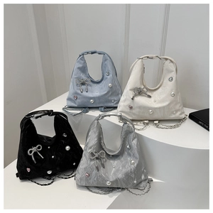 Detail of four butterfly tote bags with pearl and rhinestone accents on metal chain straps