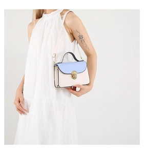 Detail of the chic light blue and beige leather handbag with gold metal twist lock