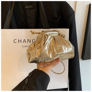 Close-up of golden metallic pleated dumpling bag featuring glossy crinkled texture
