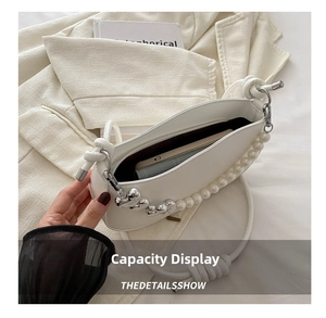 Top view of white baguette bag showing interior space for phone and long wallet