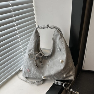 Silver metallic tote bag with crystal butterfly, pearls, and a chain strap detail