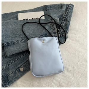 Detail of light blue nylon phone bag featuring silver metal snap button and black drawstring