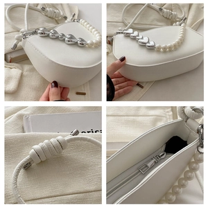 Detail showing the white half-moon bag with pearl chain and heart metal accessories