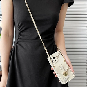 Crossbody iPhone case with cream wallet, gold chain strap, and rhinestone lettering detail