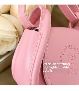 Détail des coutures et du logo gaufré sur le petit sac à main en cuir rose