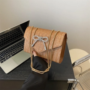 Sac à bandoulière en paille avec nœud en strass et chaîne dorée, coloris camel