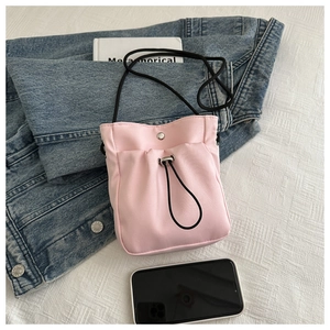 Pink nylon mini phone bag shown with accessories to display practical size and texture