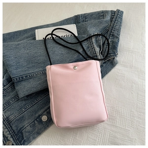 Detail of pink canvas phone bag with silver snap button and black drawstring strap