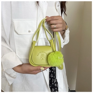 Détail du mini sac bandoulière vert fluo avec pompon duveteux et logo imprimé