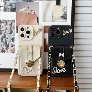 Detail of iPhone wallet case featuring rhinestone bow lock and crossbody metal chain