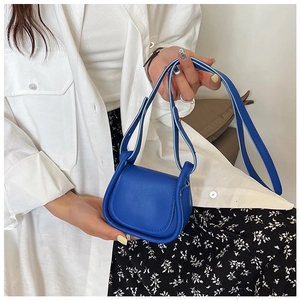 Vista dettagliata della mini borsa a tracolla blu brillante in pelle tenuta in mano