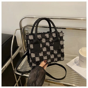 Detail der karierten Web-Tasche mit Fransen und verstellbarem Crossbody-Riemen