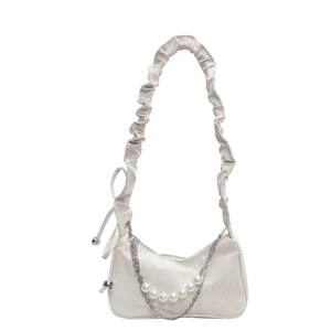 Sac à bandoulière froncé blanc avec chaîne argentée et perles sur fond blanc uni