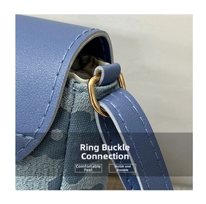 Détail de l'attache en métal doré et du tissu jacquard bleu sur le sac à bandoulière