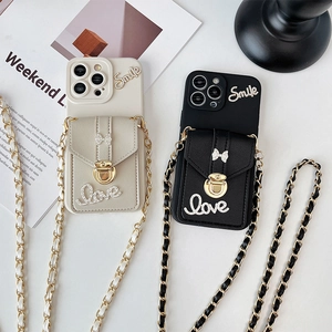 Close-up of iPhone case with mini wallet pouch, crystal bow, and crossbody chain strap