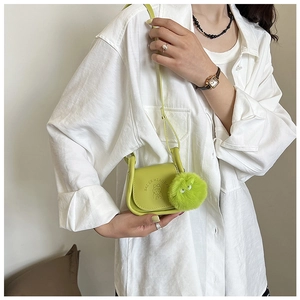 Mini sac besace vert citron avec logo embossé et porte-clé pompon vert en détail