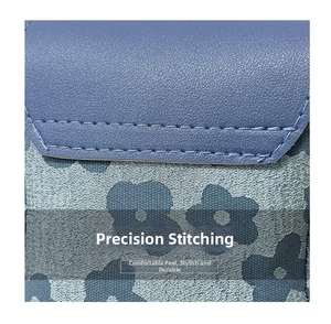 Vue détaillée des coutures de précision sur cuir litchi bleu et tissu jacquard floral