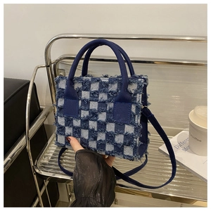 Detail der karierten kleinen Tasche mit Fransen und abnehmbarem Schultergurt